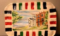 Beautiful, hand painted ceramic dish featuring the Nisbet House. These unique pieces are created by member Janet Nisbett and will look great as a trivet or table art.  Each piece is approximately 5 inches high x 7-1/4 inches wide. Stand not included.